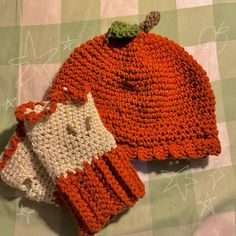 two crocheted hats sitting on top of a table