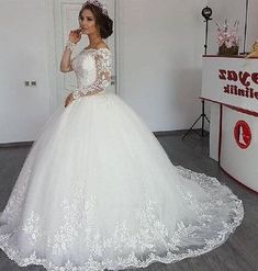 a woman in a white wedding dress posing for the camera