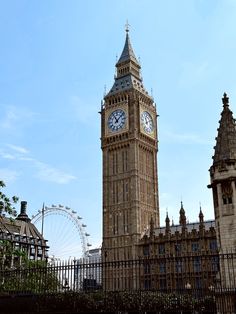 the big ben clock tower towering over the city of london with ferris wheel in the background