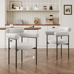 three white chairs sitting on top of a hard wood floor next to a kitchen counter