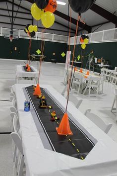 an image of a table with balloons and cones on it that are decorated for a party