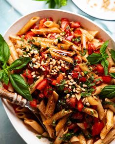 a bowl filled with pasta and vegetables on top of a table