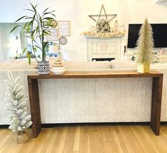 a living room filled with furniture and a christmas tree on top of a wooden table