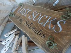 a wooden sign sitting on top of a pile of clothes pins