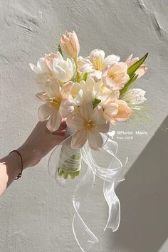 a person holding a vase with flowers in it