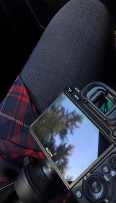 a camera sitting in the back seat of a car with its reflection on it's screen