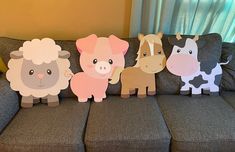 five paper farm animals sitting on top of a couch