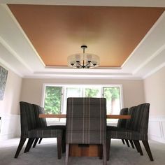 a dining room table with chairs and a chandelier hanging from the ceiling above it