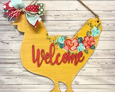 a welcome sign hanging on the side of a wooden wall with flowers and polka dots