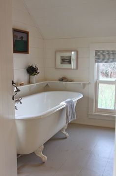 a white bath tub sitting next to a window