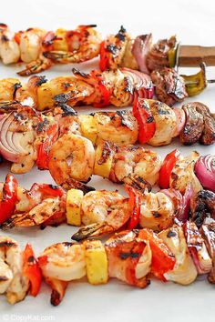 grilled shrimp and vegetable skewers on a white surface