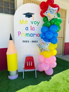 balloons and stars are on display in front of a sign that says me voy la primaria