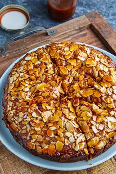 a pizza with almonds on it sitting on a plate