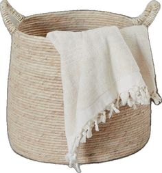 a white towel is sitting in a woven basket with two handles on the top and bottom