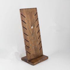 a wooden jewelry stand with two necklaces on it's sides and a white background