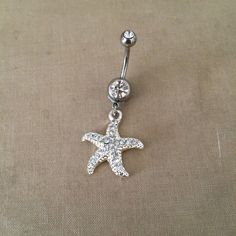 "Starfish Belly Button Ring - silver crystal belly ring, beach wedding jewelry, beach vacation, sea star, body jewelry, dangle belly ring Pretty belly ring in surgical steel with a double gem in clear and a rhinestone encrusted starfish with embossed detal   entire piece approx 1 5/8\" long. /42mm 14 gauge Large barbell rhinestone approx 7mm across - star pendant Approx 7/8 (24mm) long  Comes in an organza gift bag matching necklace available To keep the rhinestones looking their best I recommend you do not wear this piece while swimming or bathing. NOT RECOMMENDED FOR THOSE WITH SENSITIVE SKIN, METAL ALLERGIES, OR NEW PIERCINGS also in gold https://www.etsy.com/listing/206653692/belly-button-ringstarfish-bellybutton I DO NOT OFFER RETURNS or EXCHANGES, so please select carefully, thank yo Bellybutton Ring, Wedding Jewelry Crystal, Bellybutton Rings, Cute Belly Rings, Belly Button Piercing Jewelry, Beach Wedding Jewelry, Belly Piercing Jewelry, Belly Piercing Ring, Gold Belly Ring