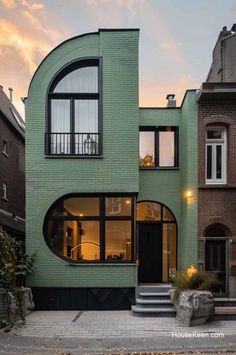 a green building with lots of windows on the front and side, along with steps leading up to it