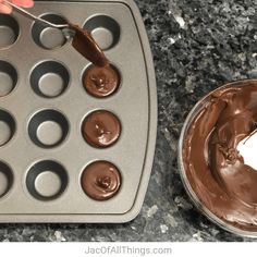 someone is spreading chocolate into a muffin tin