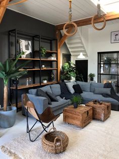 a living room filled with lots of furniture and plants on top of a white rug