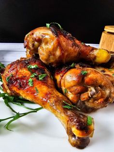 two pieces of cooked chicken sitting on top of a white plate