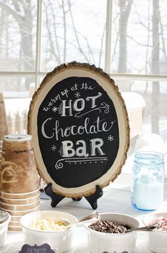 there is a sign that says hot chocolate bar in front of some bowls and jars