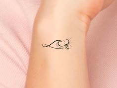 a woman's arm with a small tattoo design on the left side of her arm