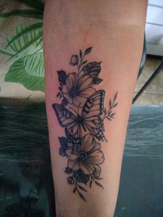 a butterfly and flowers tattoo on the leg