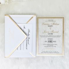 a wedding card and envelope on a white furnishing with flowers in the background