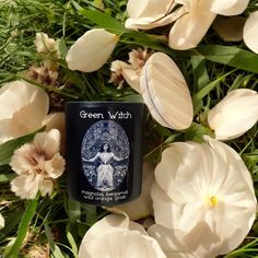 the green witch candle is surrounded by flowers