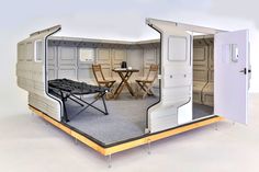 the interior of a mobile home with an outside kitchen and dining area in it, as well as two folding chairs