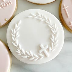 cookies decorated with white frosting and pink icing are arranged in the shape of wreaths