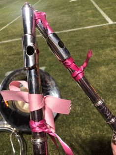 a pink ribbon is tied to the handlebars of a bicycle