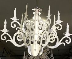 a chandelier made out of white paper with intricate designs hanging from the ceiling