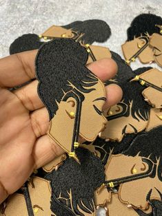 a person is holding some black and gold patches