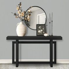 a vase with flowers is sitting on a table next to a mirror and candle holders