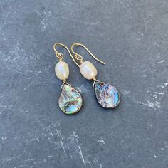 Los días de playa y los tacos van de la mano, y los aretes Abalone Shell Teardrop with Pearl son el accesorio perfecto para tal ocasión. Pero la elegancia atemporal de estas piezas clásicas de verano las hace adecuadas para una variedad de entornos, ya sea cerca de la playa o lejos. Esta pieza, que mide 1 5/8" (~40 mm) desde la parte superior del alambre de la oreja hasta la parte inferior de la concha, está disponible en su elección de plata de ley o bañada en oro. Con su belleza orgánica única, cada lágrima de concha de abulón con Pearl tiene su propio carácter, expresado a través de sutiles variaciones en el tono del color y las estrías. Abalone Jewelry, Los Tacos, Summer Pieces, Paua Shell, Blue Pearl, Abalone Shell, Beach Days, Organic Beauty, White Pearl