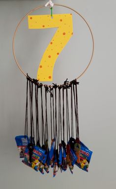 a number seven hanging from a hoop with chocolate candies in front of it on a wall