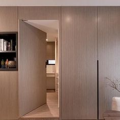 an open door leading to a living room filled with furniture and bookshelves on the wall