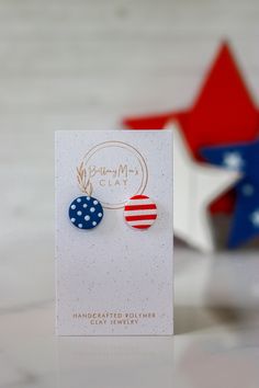 a pair of red, white and blue earrings on top of a card