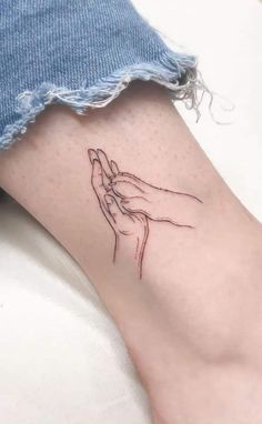 a woman's foot with a tattoo on it that has a drawing of a praying hand