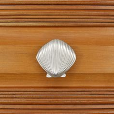 a close up of a wooden drawer with a shell on the front and bottom part