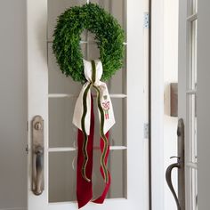 a door with a wreath and ribbon hanging on it