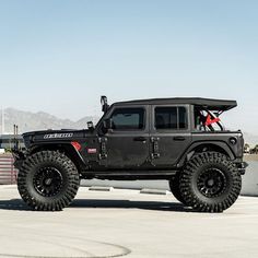 a black jeep parked on top of a parking lot