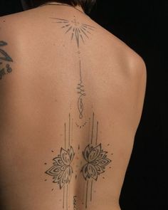 the back of a woman's body with tattoos on it