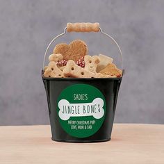 a black bucket filled with dog treats on top of a table