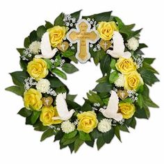 a wreath with yellow roses and white doves is shown in front of a cross