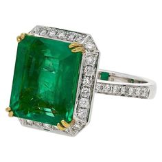 Centering an 8.47 carat Emerald-Cut Colombian Emerald, accented by 0.55 carats of Round-Brilliant Cut Diamonds, and set in 18K White/Yellow Gold, this lush green Emerald Ring is sure to steal the show! Details: ✔ Gemstone: Emerald ✔ Color: Vivid Green ✔ Gemstone Weight (Carat): 8.47ct ✔ Gemstone Cut: Emerald ✔ Ring: 18K, 0.55 carats Round-Brilliant Cut Diamonds ✔ Metal: 18K White/Yellow Gold ✔ Diamonds: Round-Brilliant Cut, 0.55ct total ✔ Weight: 7.01g Sapphire Engagement Ring Halo, Vintage Emerald Engagement Ring, Emerald Ring Engagement Diamond, Sparkling Jewelry, Emerald Wedding Rings, Green Emerald Ring, Vintage Cocktail Ring, Diamond Jewelry Designs, Diamond Anniversary Rings