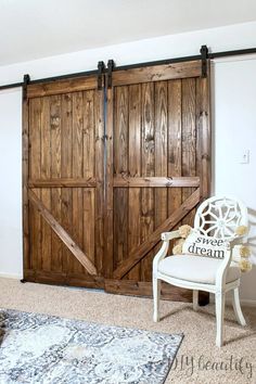 a white chair sitting in front of a wooden barn door with sliding doors on it