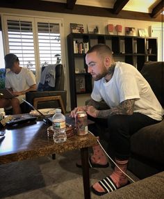 a man sitting on top of a couch next to a table