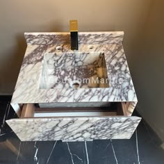 a bathroom sink with marble counter top and gold faucet